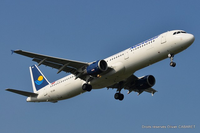 Large jetliner in flight with its landing gear down.
