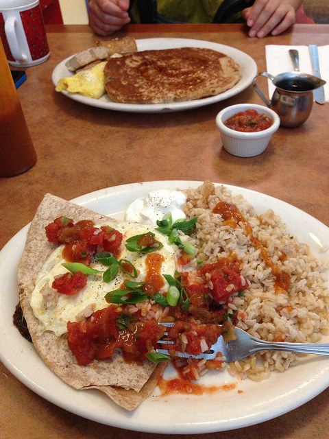 Meal with rice on the plate in the foreground.