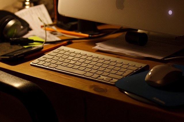 Desk with a keyboard and an Apple mouse on the right.